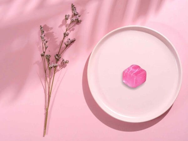 Pink French Fancy pin badge displayed on a pink plate against a pink gradient background.