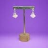 Polymer Clay Ghost earrings on a metal stand against a purple background.